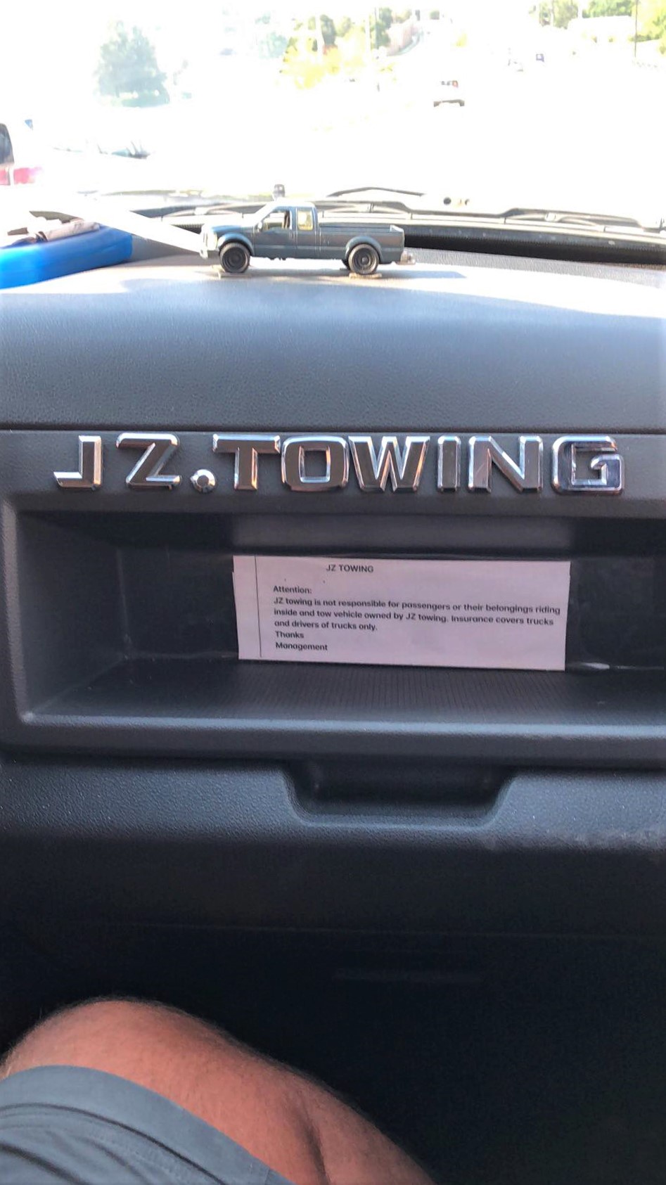 The name JZ Towing on the dashboard of the flatbed truck that we rode in