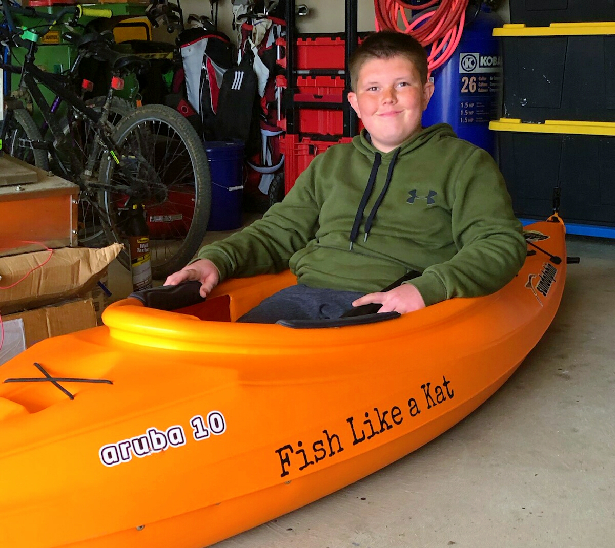 Hunter testing out his new kayak in his family's garage